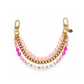 A double-strand charm bracelet featuring light pink faux pearls, gold-tone chain links, bright pink faceted crystal beads, and white letter beads spelling 'PRINCESS' on a white background & Gold letters