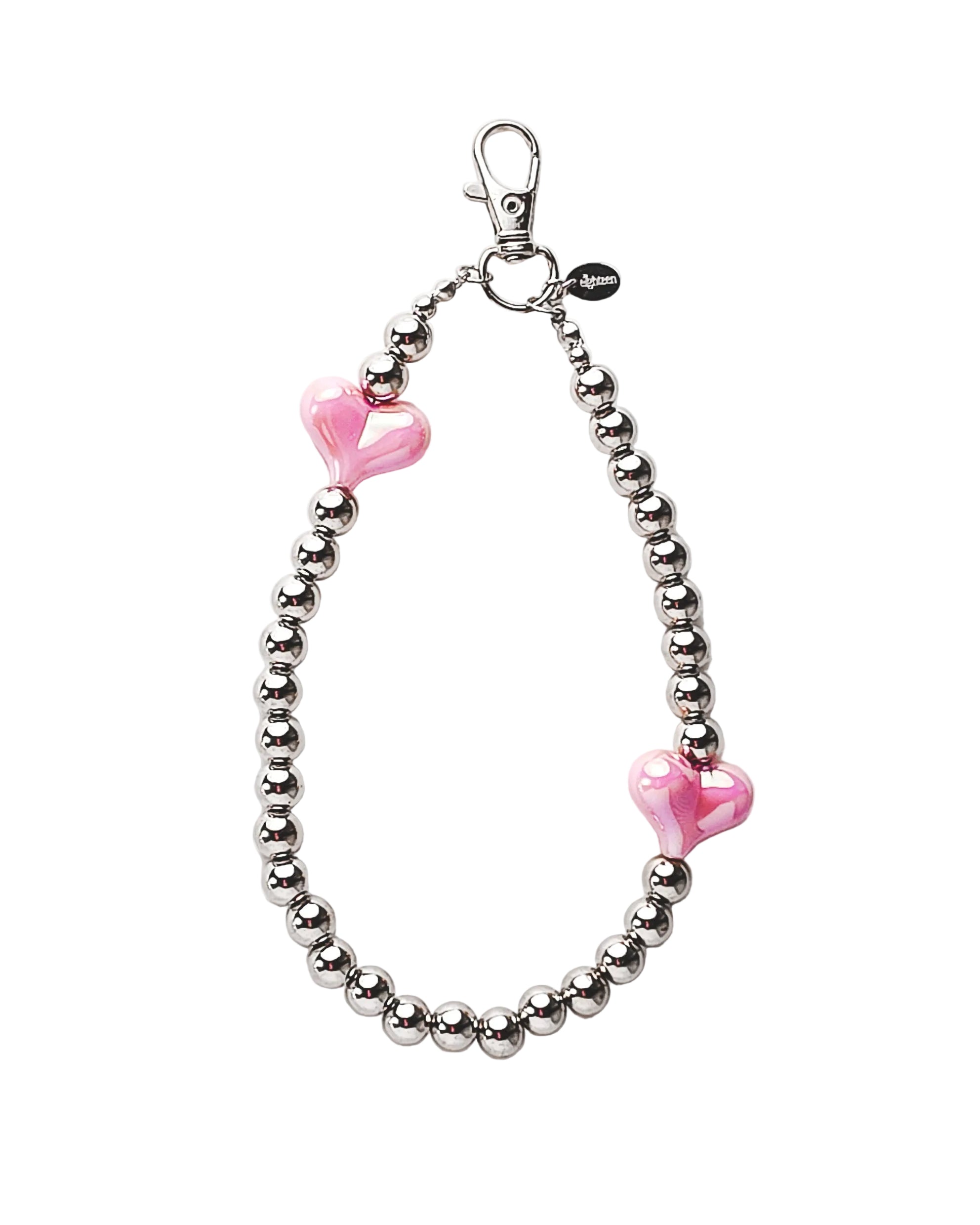 A silver beaded bracelet with two pink heart-shaped beads, featuring a lobster clasp closure and a small black tag, displayed on a clean white background.