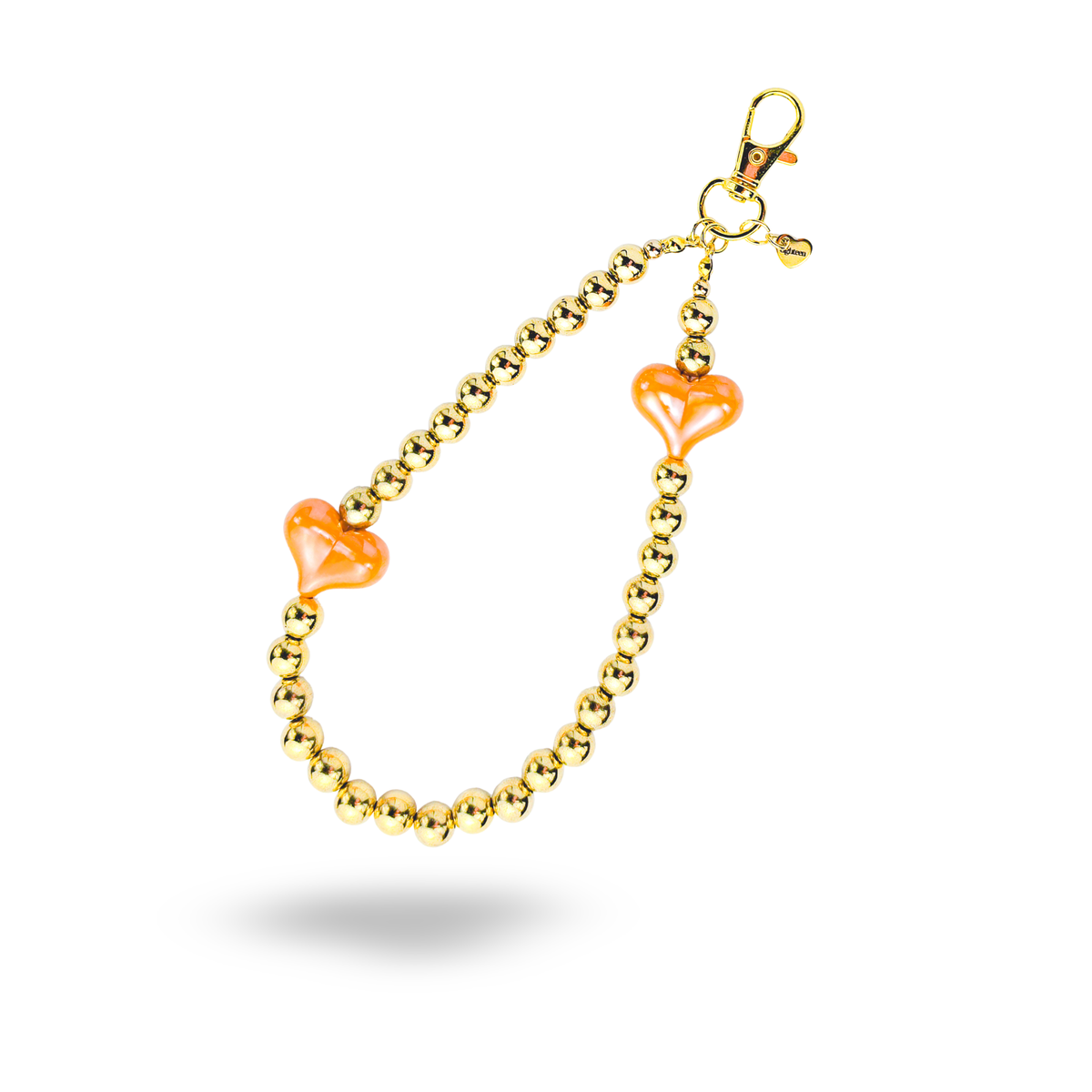 A gold beaded Phone charm with two translucent orange heart charms, shown on a clean white background with a soft drop shadow.
