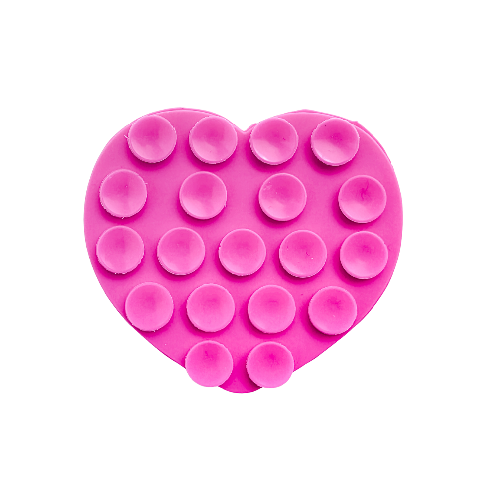 A bright pink heart-shaped silicone phone suction grip with raised circular cups, shown on a plain white background.