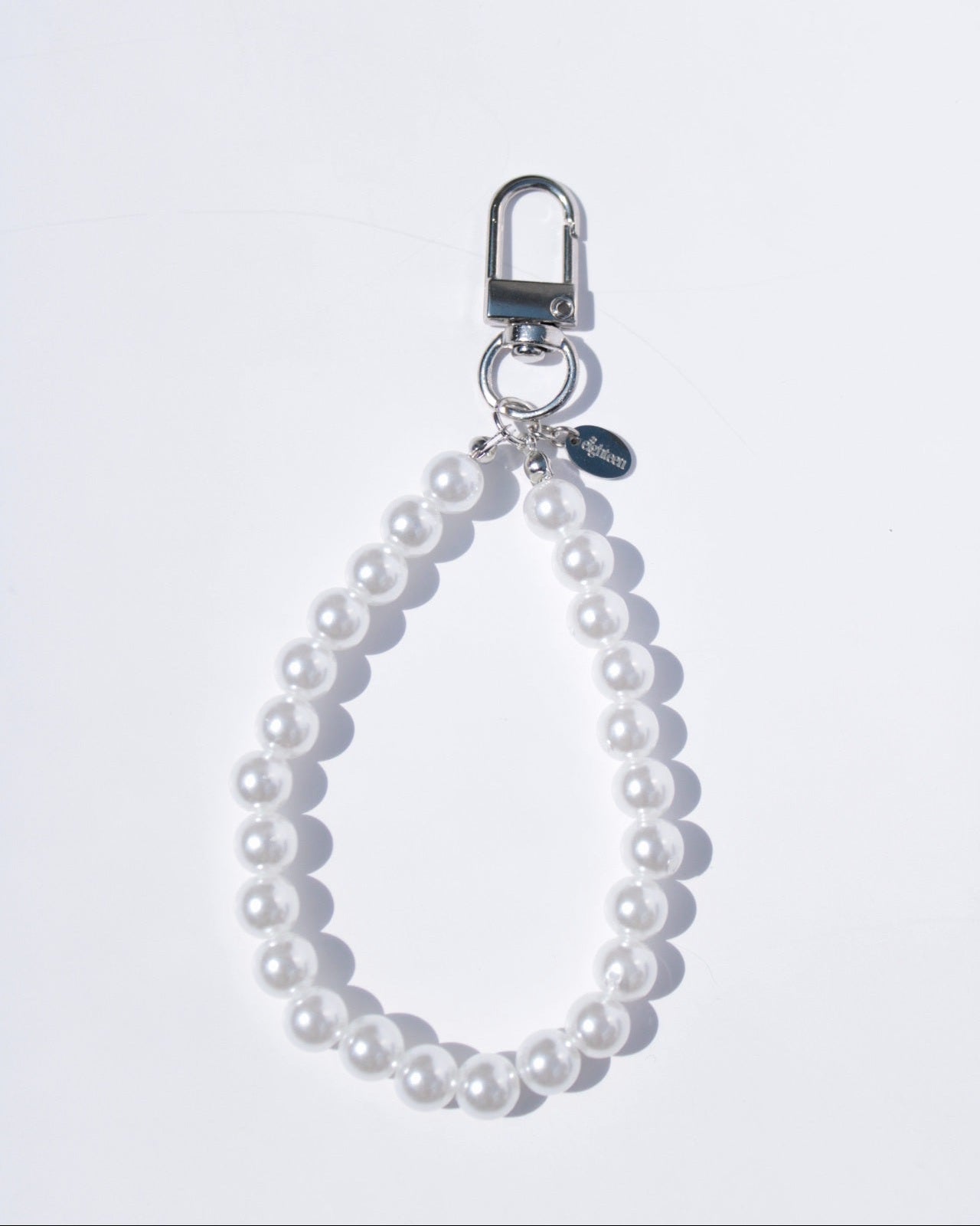 Pearl keychain with silver clasp on a white background