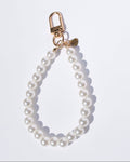 Pearl keychain with gold clasp on a white background