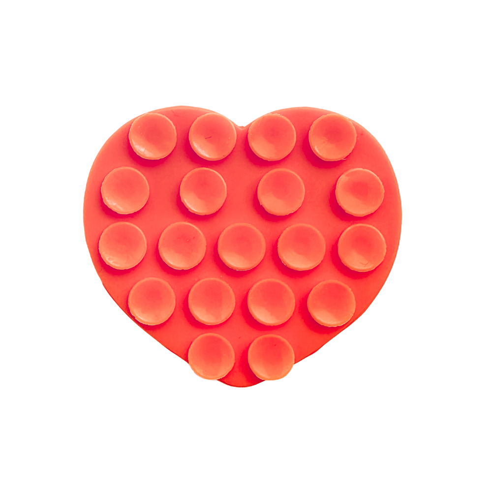An orange heart-shaped silicone phone suction grip with raised circular cups, shown on a plain white background.