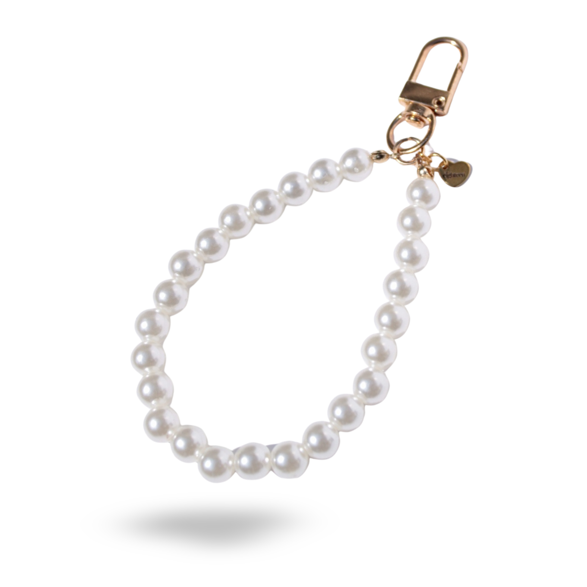 A white pearl phone charm with a gold clasp and heart shaped brand tag