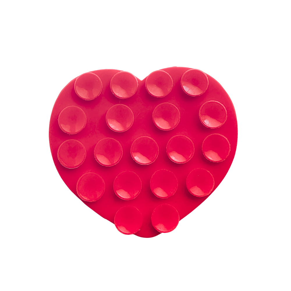 A red heart-shaped silicone phone suction grip with raised circular cups, shown on a plain white background.