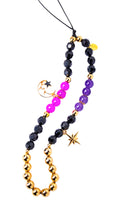 Necklace with black, purple, and gold beads on a white background